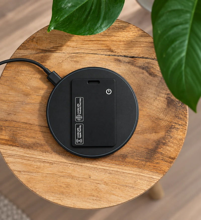 TYVEXO Smart Card charging wirelessly on a wood stump with plant leaves